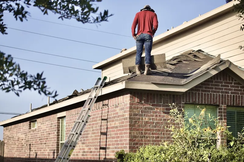 Professional roofer working on a residential roof in Village of Nagog Woods